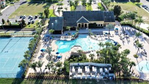 An aerial view of a resort with a large swimming pool, tennis courts, and a covered seating area. - Only Minutes to Disney (Kissimmee)