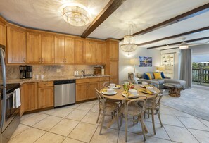 Eine moderne Küche mit Holzausstattung, Edelstahlgeräten und einem Essbereich mit rundem Tisch und Stühlen.