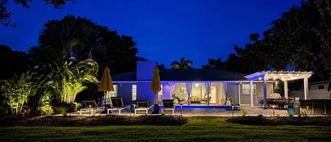 Une maison dotée d’un patio couvert, d’un espace salon extérieur et d’une piscine.