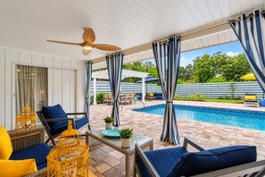 A covered outdoor area with a pool, seating, and a ceiling fan. - Modern Coastal Pool Retreat • Private Heated Pool • Minutes to Siesta Key Beach (Sarasota)