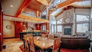 A spacious kitchen with high ceilings and a stone fireplace. - Castle Butenham by Cottonwood Lodging (Brighton)