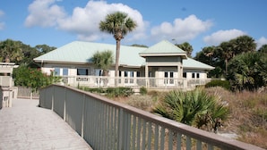 A large, single-story building with a green roof and a covered walkway leading to it. - Tennismaster 203 (Hilton Head Island)