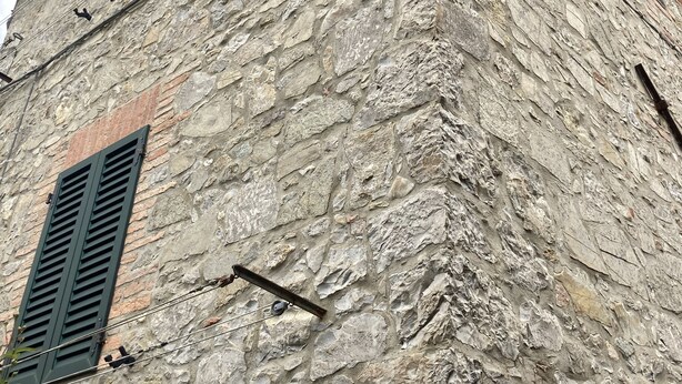 A stone building with two windows and a wooden roof. - Exclusive Stone Tower. (Casciano)