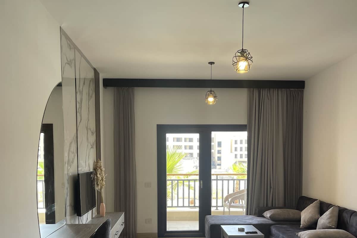 Une chambre d’hôtel moderne équipée d’un grand lit, d’un canapé, d’une table à manger et d’un téléviseur.