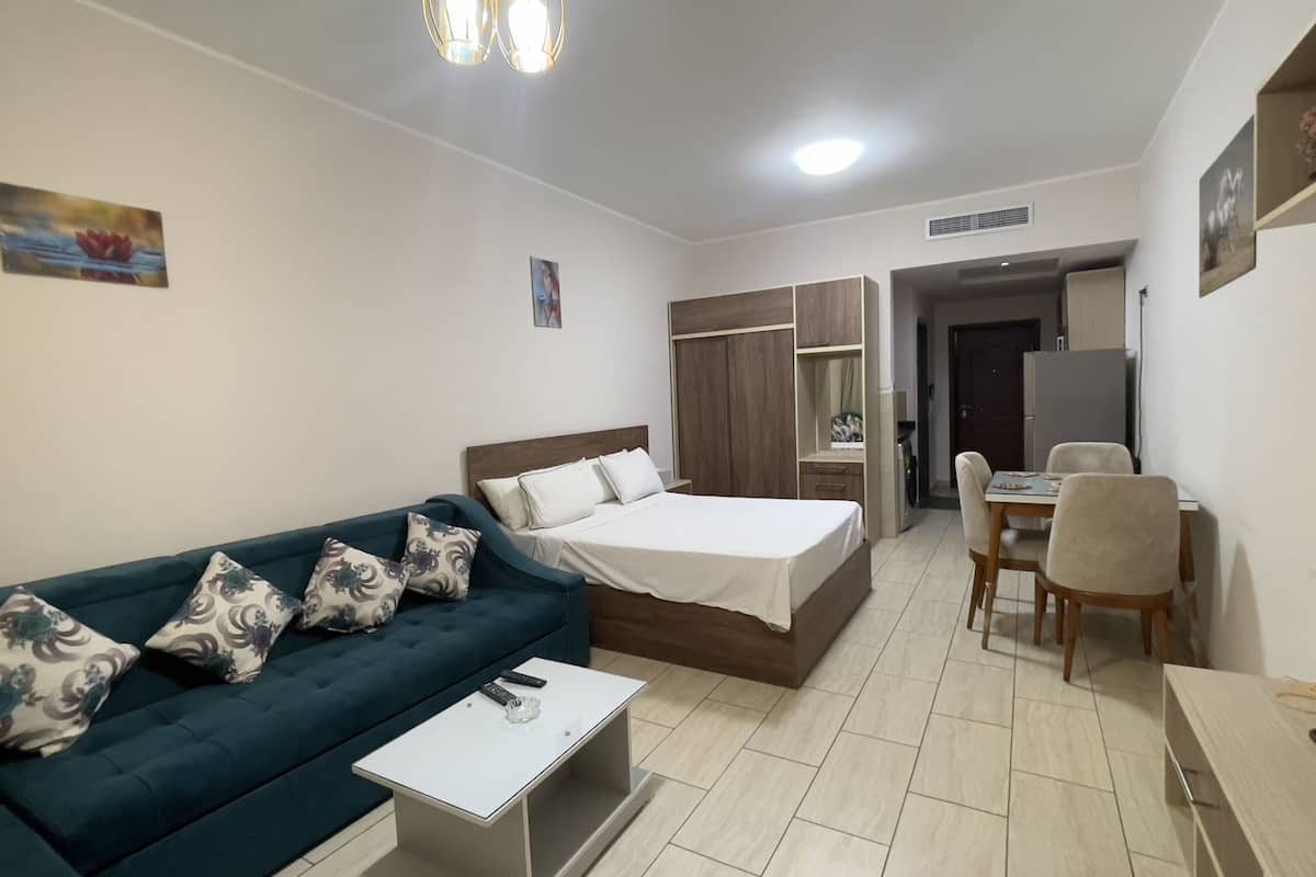 Une chambre d’hôtel de taille réduite, comprenant un lit, un canapé, une petite table, un bureau et une chaise.