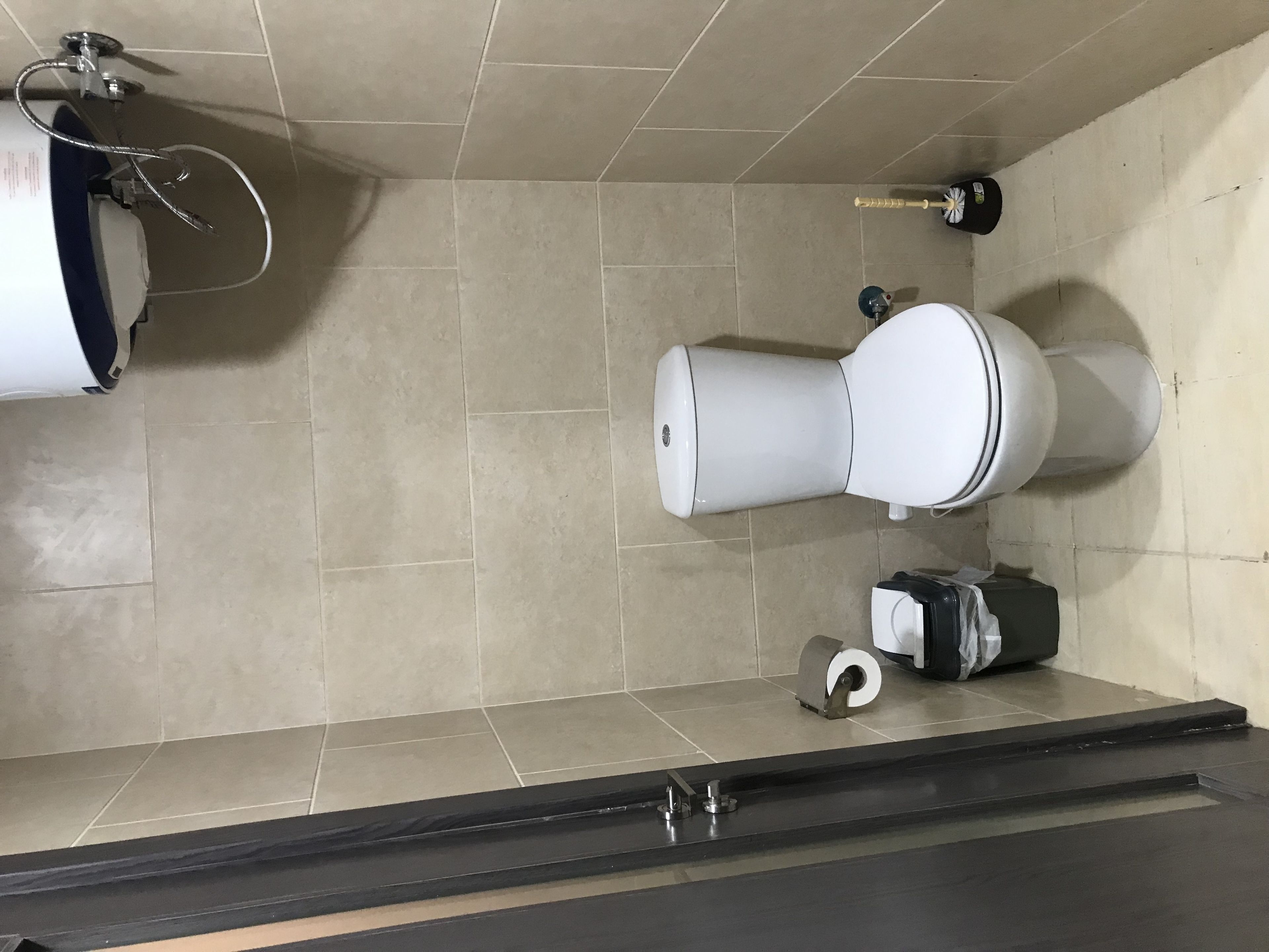 Un baño moderno con inodoro, bidé y dispensador de toallas.