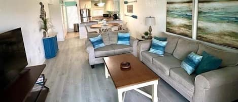 A living room with a sofa, coffee table, and a TV.