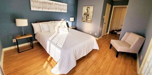Cozy retreat with a large bed, bedside tables, and a comfortable chair.
