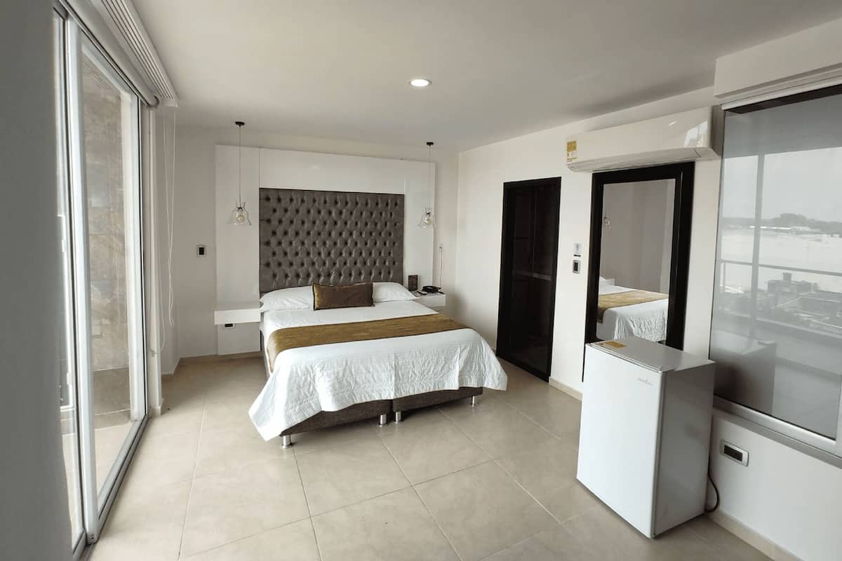 A modern bedroom with a large bed, a wardrobe, and a built-in TV.