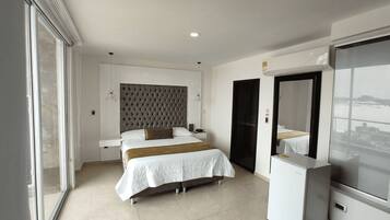 A modern bedroom with a large bed, a wardrobe, and a built-in TV.