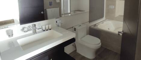 Un baño moderno con un lavamanos grande, inodoro y bañera.