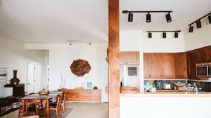 Una cucina moderna con mobili in legno, un'isola centrale e luci a sospensione.