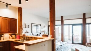 Una cucina moderna con mobili in legno, un'isola centrale e un'ampia finestra che lascia entrare luce naturale.