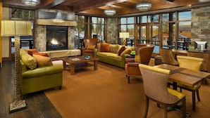 A spacious living area with a stone fireplace, leather sofas, and a dining table. - Welk Resorts- 2 BD NORTH VILLAGE #1 (Truckee)