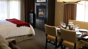 A hotel room with a bed, a dining table set for two, a fireplace, and a large window with curtains. - Welk Resorts- 2 BD NORTH VILLAGE #1 (Truckee)