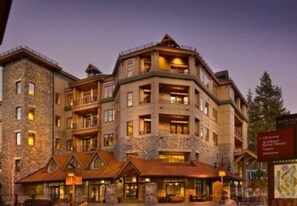 Un hôtel à plusieurs étages, doté d’une façade en pierre et de nombreux balcons, et arborant une enseigne indiquant les services proposés.
