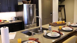 A modern kitchen with dark cabinets, stainless steel appliances, and a breakfast setup on the island. - Welk Resorts- 2 BD NORTH VILLAGE #1 (Truckee)