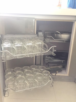 A kitchen with shelves holding glassware and utensils. - Adi Villa 2 (Ho Chi Minh City)