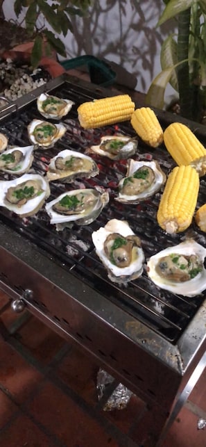 A grill with oysters and corn on it. - Adi Villa 2 (Ho Chi Minh City)
