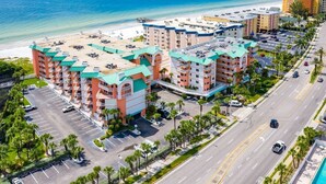Ein Hotel mit mehreren Etagen, einem Parkplatz und Blick auf den Strand.