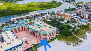Luftaufnahme eines Küstenhotels mit mehreren Gebäuden, einer Marina und einem Fluss.