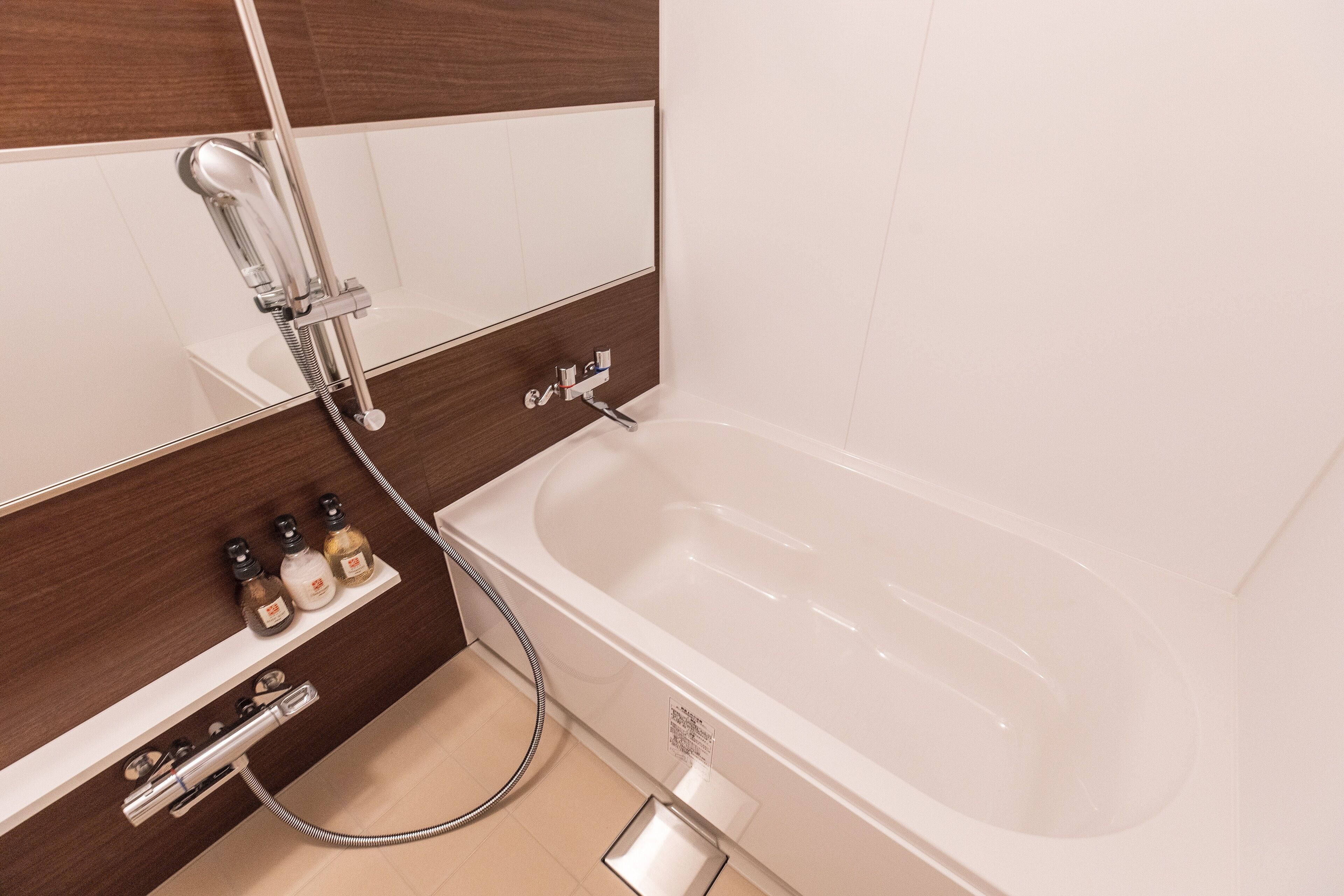 A modern bathroom with a bathtub, a shower, and a vanity with toiletries.