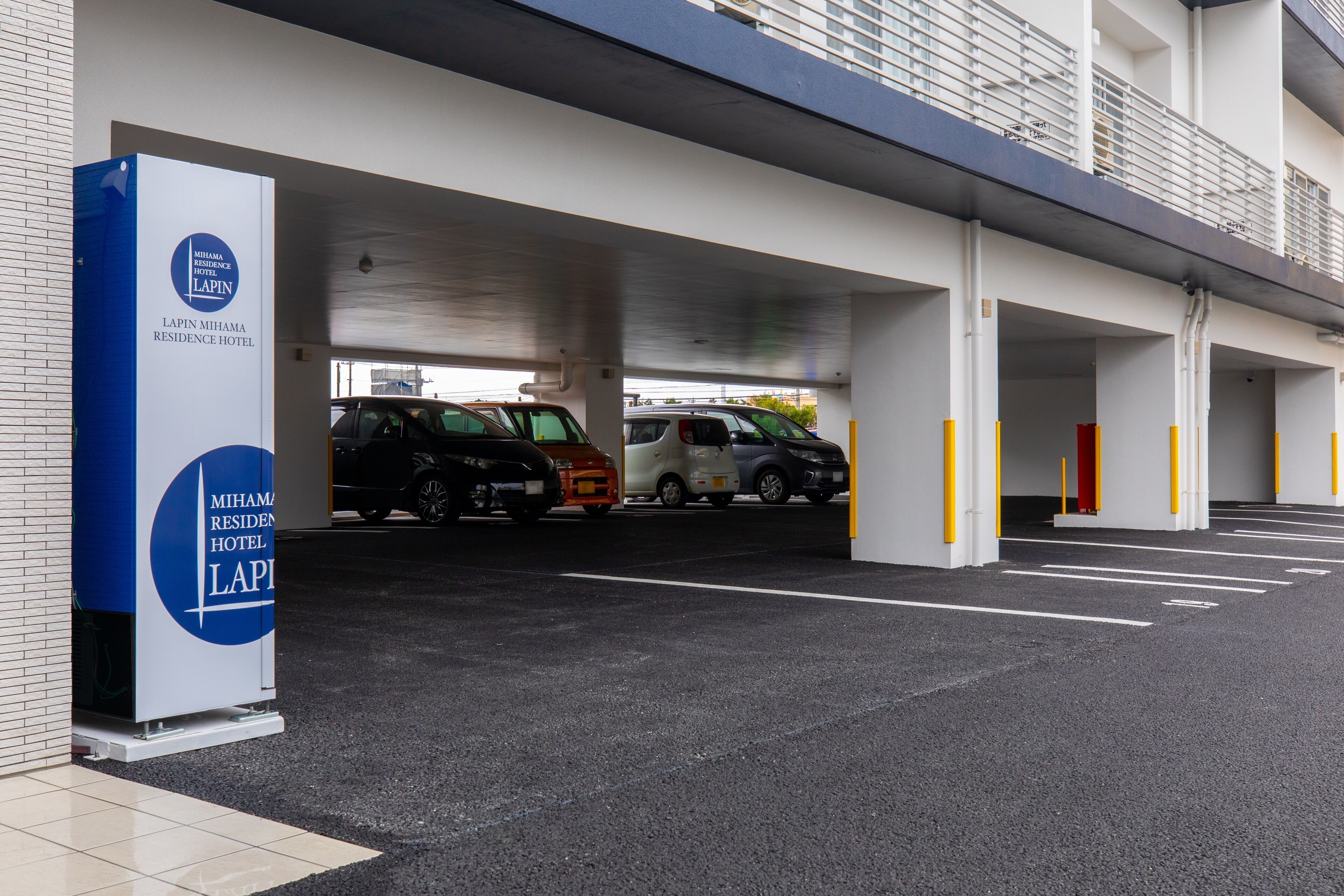 Un parking couvert où plusieurs voitures sont stationnées.