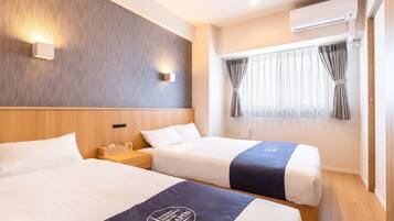 A hotel room with two beds, a wooden headboard, a wall-mounted air conditioner, and a window with curtains.