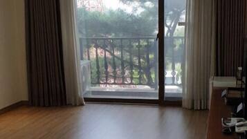 A spacious room with a large sliding glass door leading to a balcony.