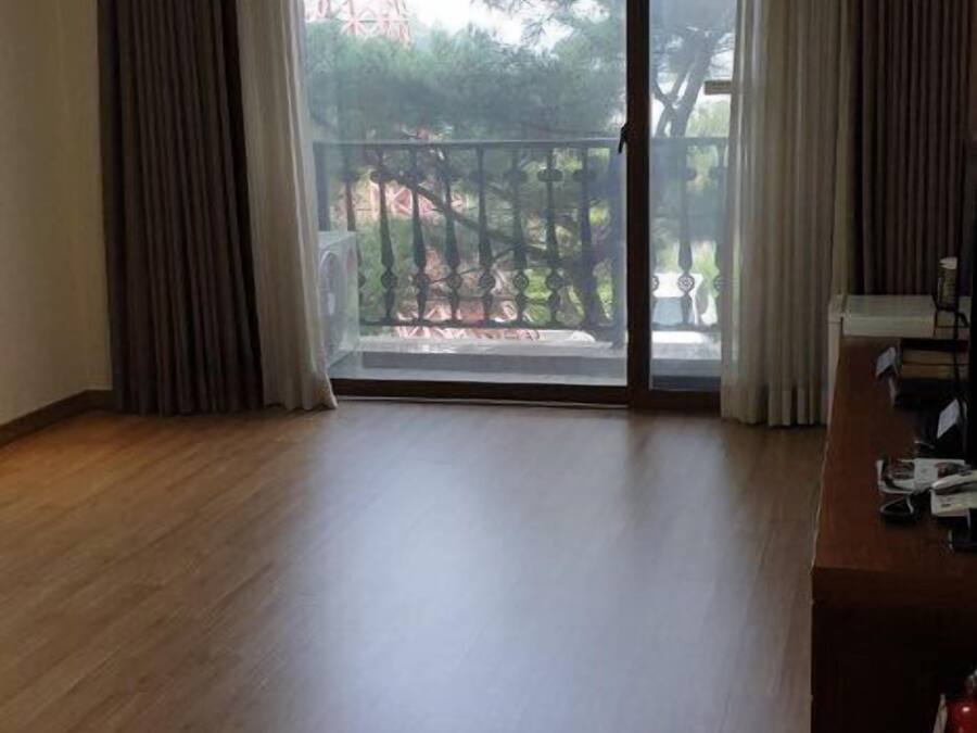 A spacious room with a large sliding glass door leading to a balcony.