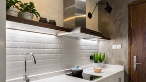 Une cuisine moderne avec des meubles blancs, un évier en acier inoxydable et un carrelage à motifs.