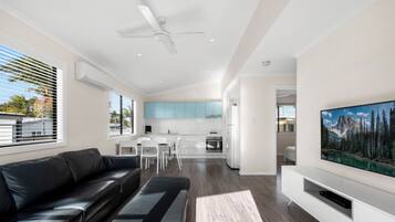 Hytte – deluxe, hageutsikt | Oppholdsområde | Flatskjerm-TV, TV-spill og DVD-spiller