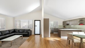 A modern apartment with a living room, dining area, and kitchen. - Mountain View Resort (Shoalhaven Heads)