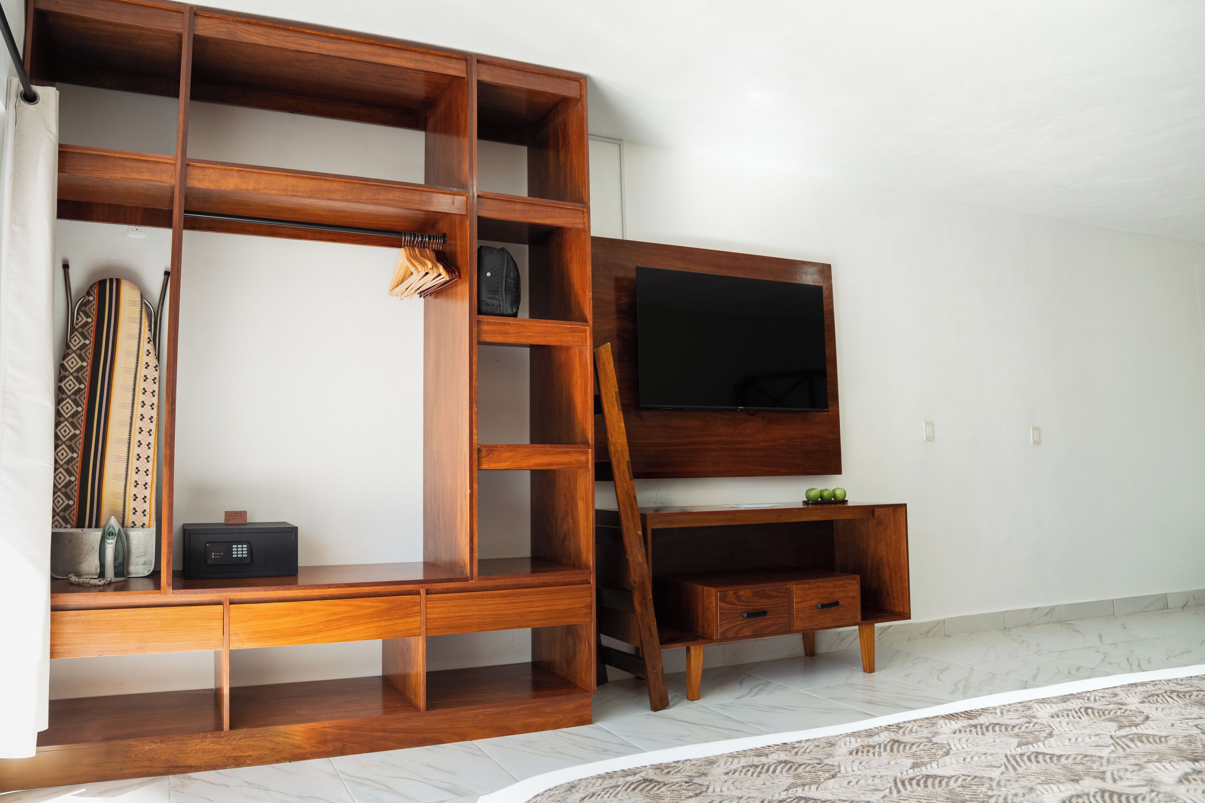 A wooden entertainment unit with a TV, drawers, and shelves.
