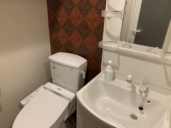 A bathroom with a toilet, bidet, and sink.