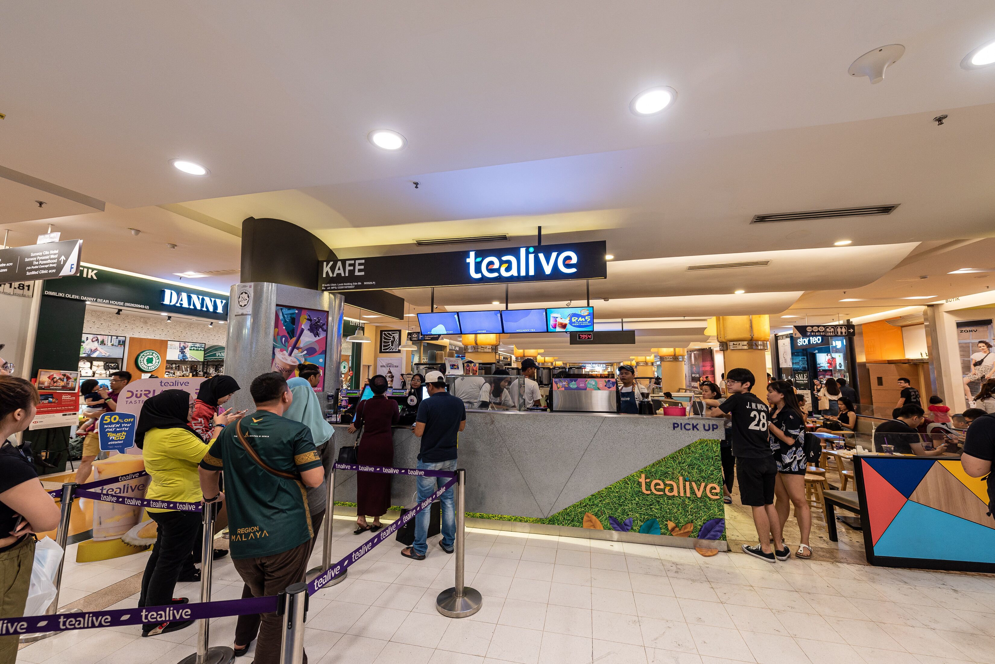 A food court area with multiple food outlets, including a 'tealive' kiosk and a 'DANNY' restaurant.