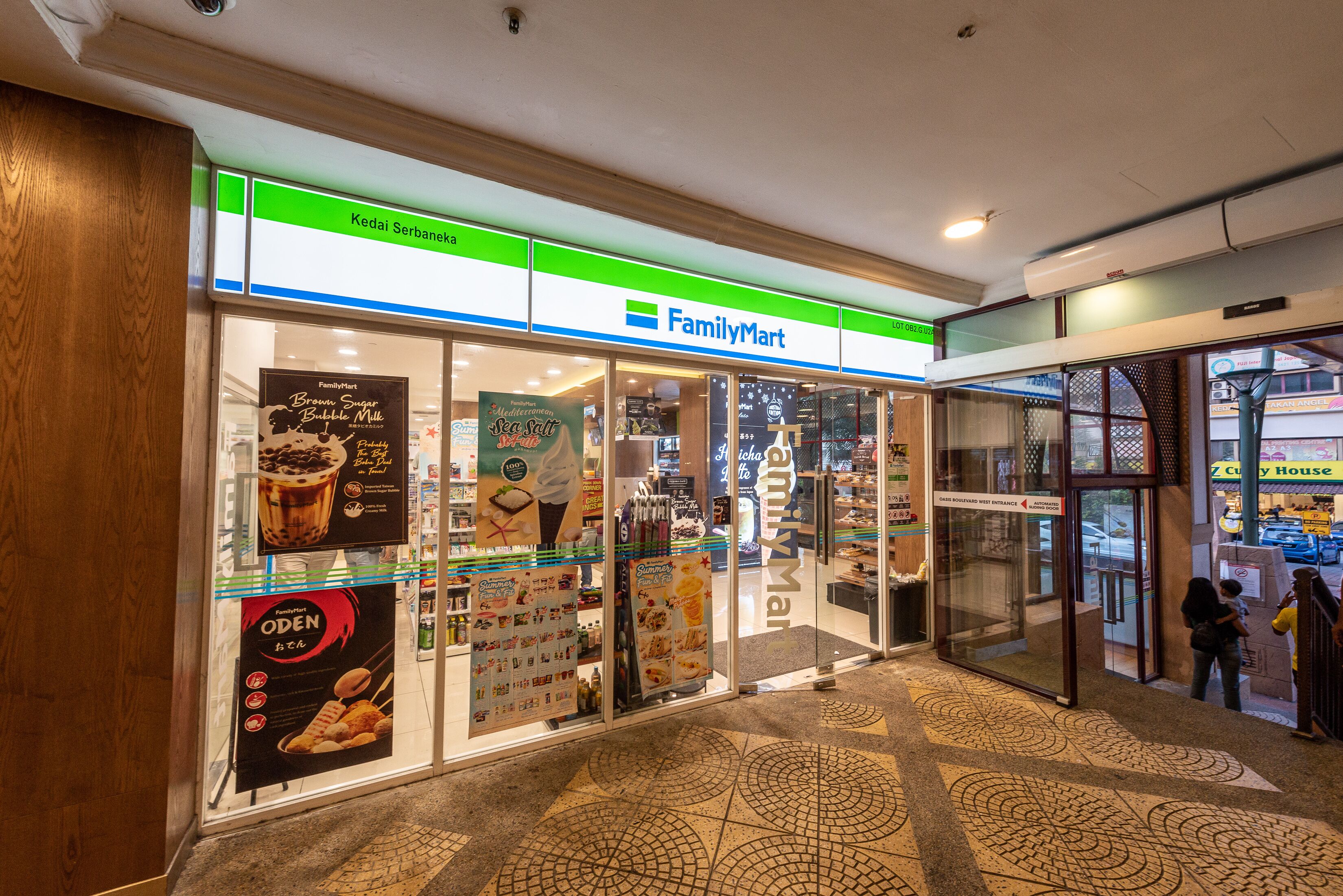 Una tienda FamilyMart con señalización clara, piso de baldosas y vista a la calle.