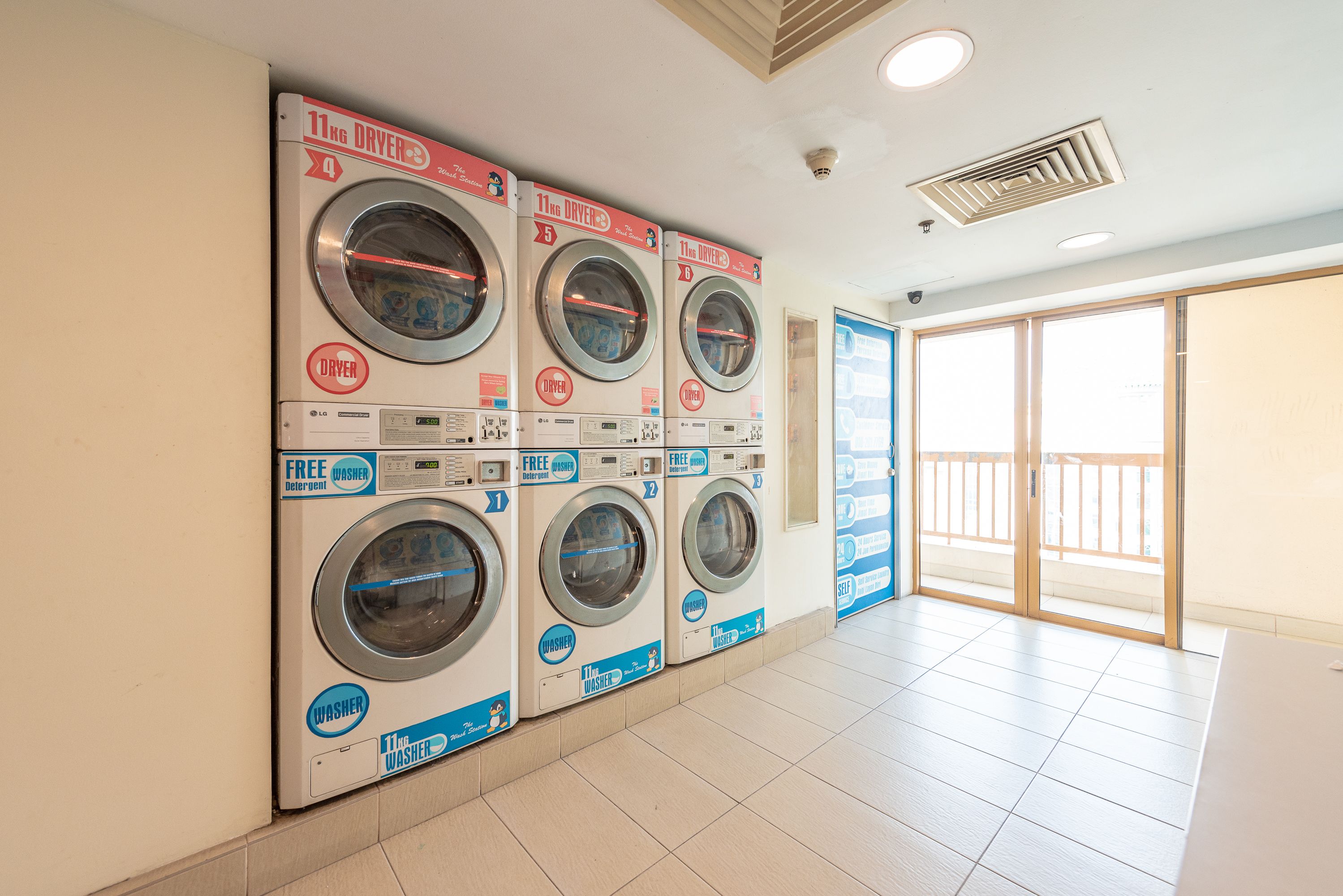 A laundry facility with four washing machines, each labeled with a different capacity.