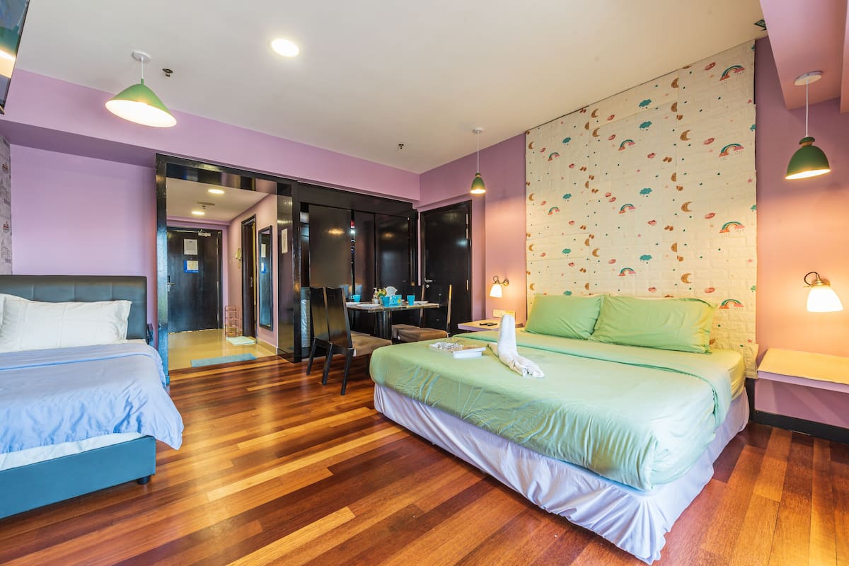 A hotel room with a large bed, a desk, and a mirror.