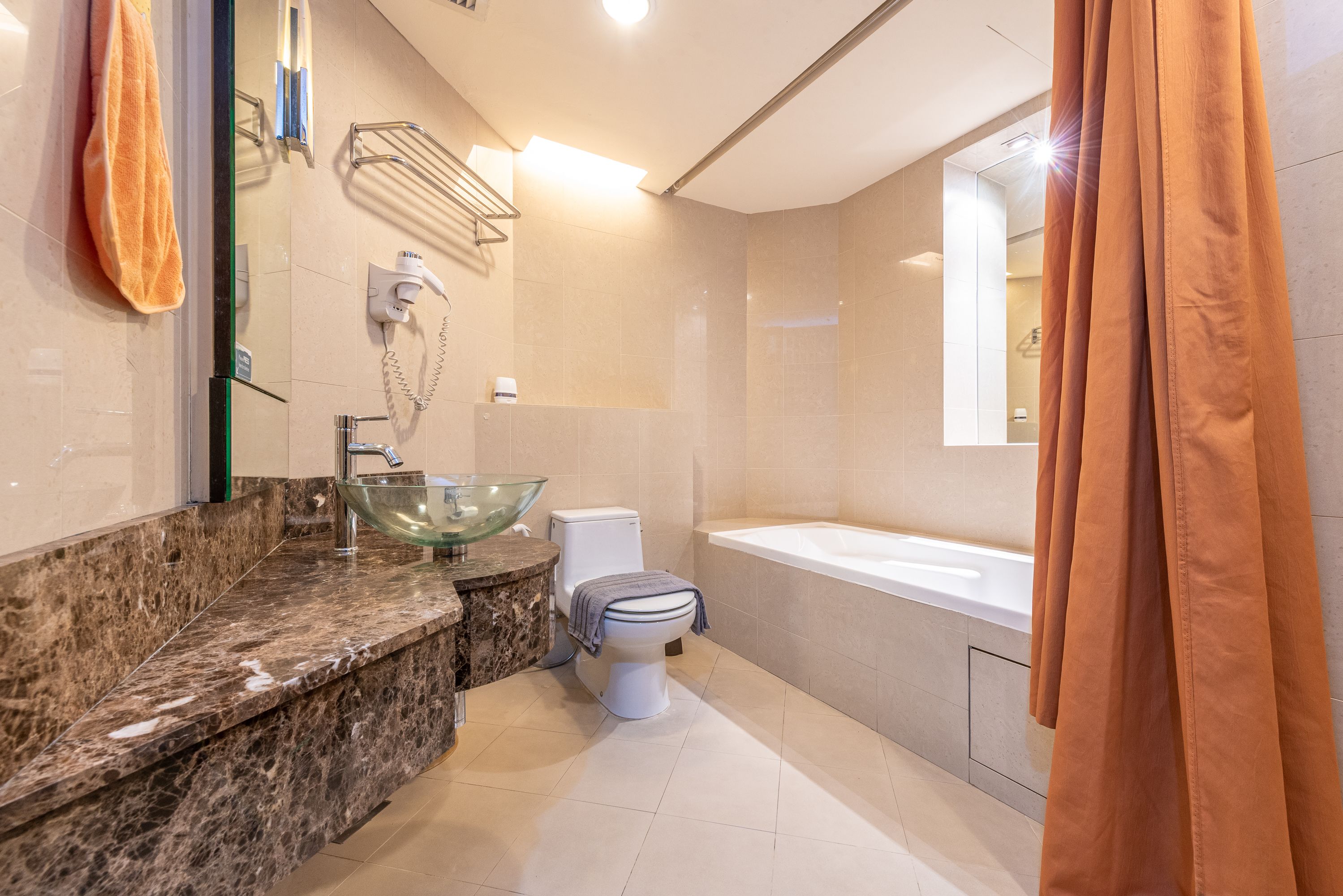 Un bagno con lavabo in vetro, un water e una vasca da bagno.