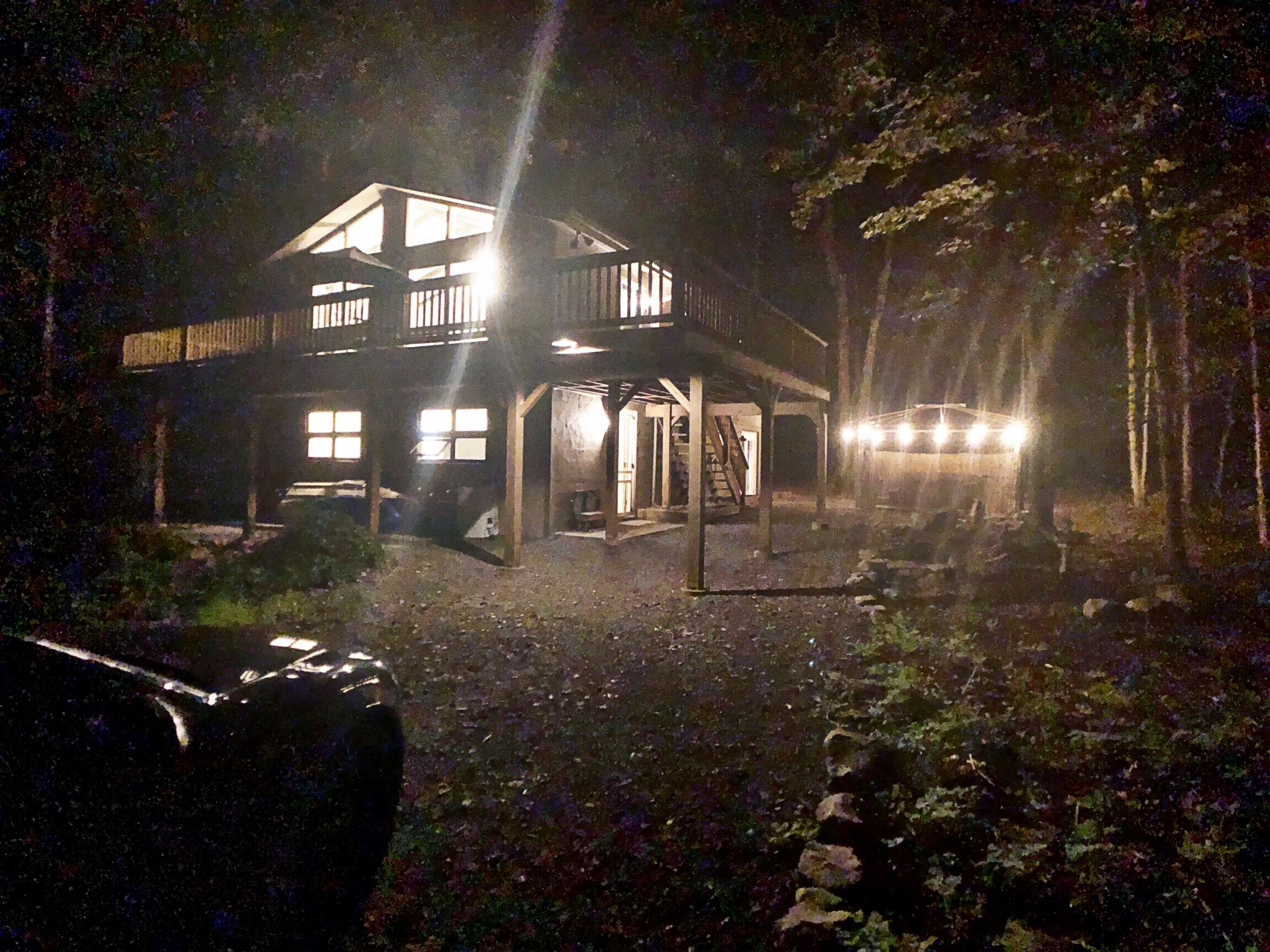 A two-story house with a porch and a staircase leading to the upper level.