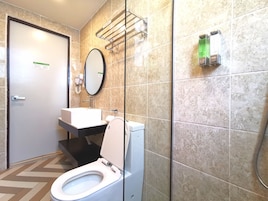 A bathroom with a toilet, sink, and mirror.