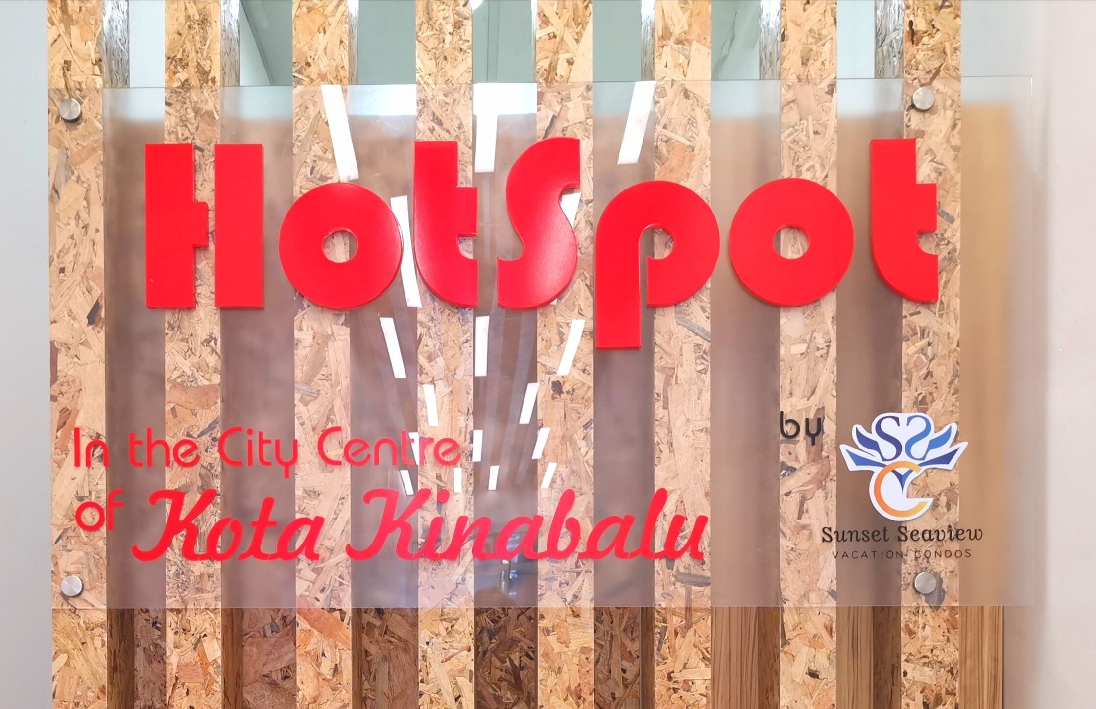Un letrero con la palabra 'Hotspot' en letras rojas, que indica una ubicación en Kota Kinabalu.