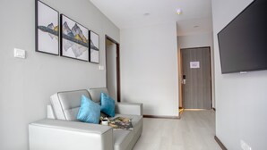 A modern hotel lobby with a white leather sofa, blue cushions, and framed artwork on the wall. - HotSpot at City Centre by SSVC (Kota Kinabalu)