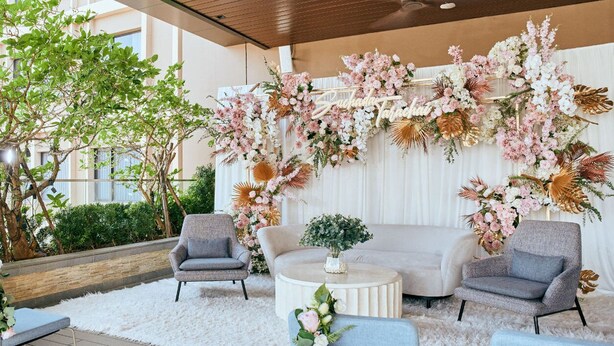 A modern indoor space with a seating area, a white wall with floral decorations, and a ceiling fan. - Sindhorn Midtown Hotel Bangkok, Vignette Collection by IHG (Bangkok)