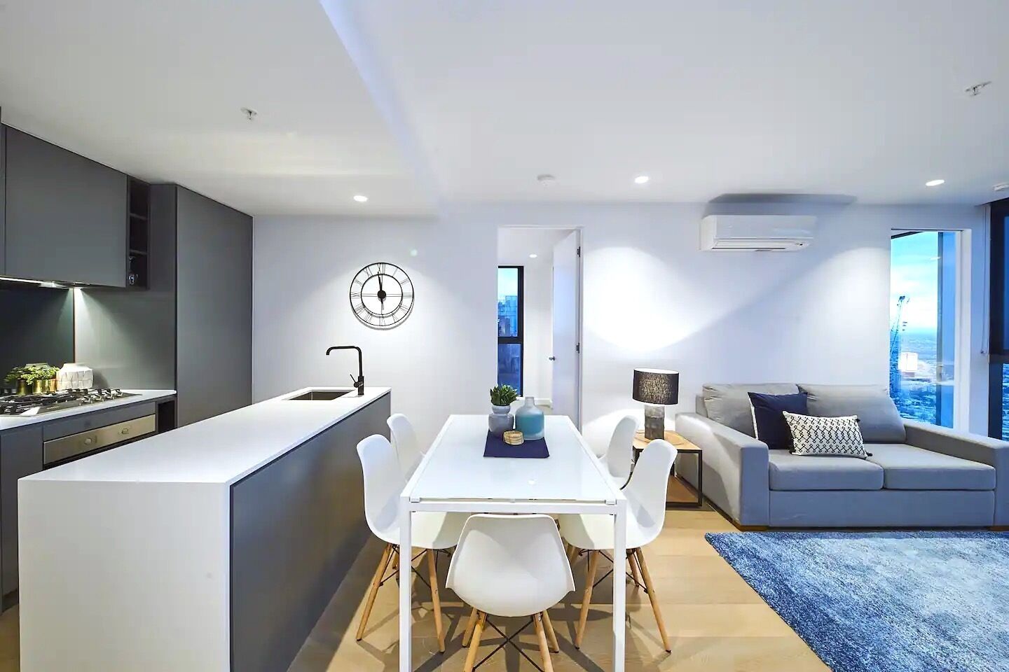 A modern apartment with a kitchen, dining area, and living room.