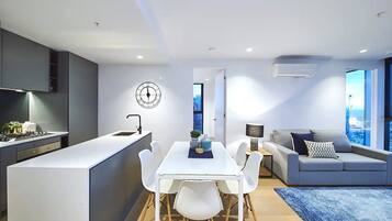 A modern apartment with a kitchen, dining area, and living room.