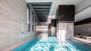 Una piscina interior con agua cristalina, paredes de azulejos y un diseño moderno.