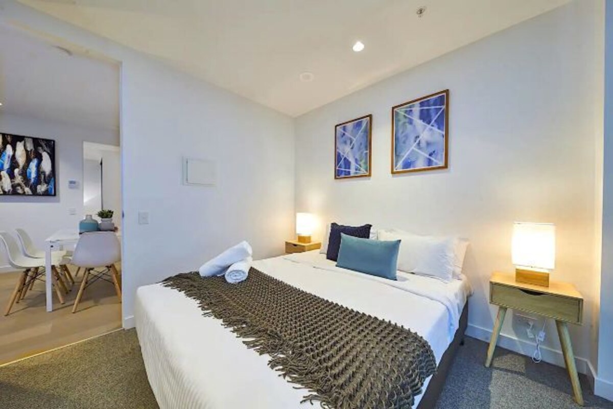 Une chambre d’hôtel comprenant un lit, des tables de chevet, un bureau et des chaises.
