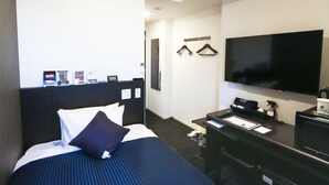 A hotel room with a bed, a desk, a TV, and an air conditioning unit. - Hotel Livemax Shinjuku East (Tokyo)